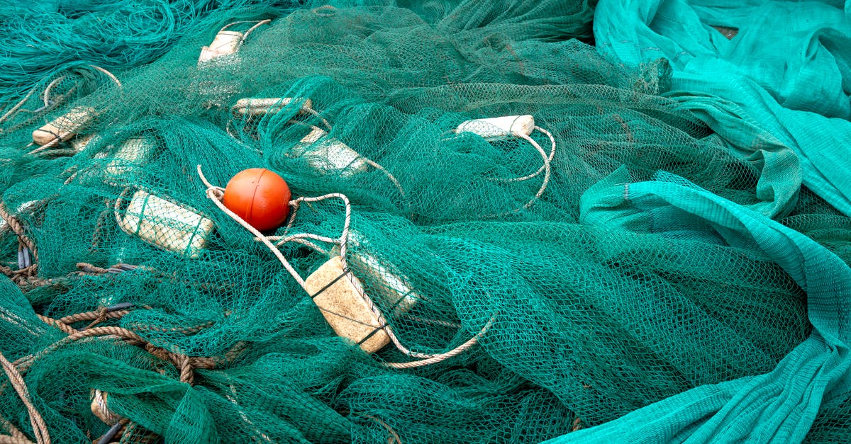 Do different fishing holes have different odds? - High angle of fishing net with floats and ropes against creased green fabric in daytime