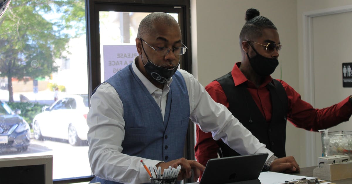 Do i keep foreign passports after i confiscate them? - Man Using an iPad Beside His Friend 