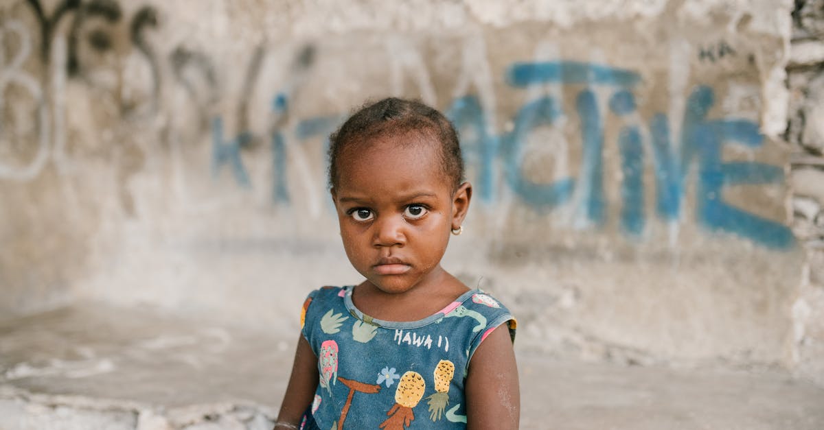 Do I need to delete my own logs? - Frowning African American girl near weathered concrete building with vandal graffiti and broken wall in poor district