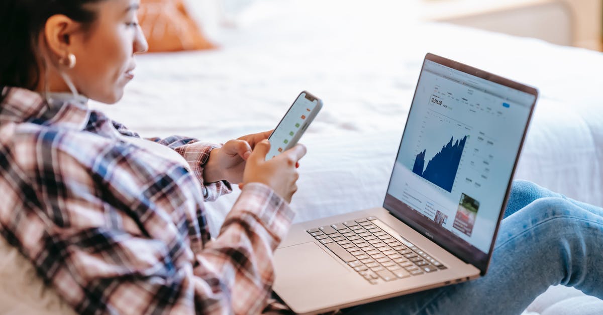 Does deltaV have a limit using only stock parts? - Side view of crop ethnic female dealer using trading app on cellphone against netbook with graph on screen in house