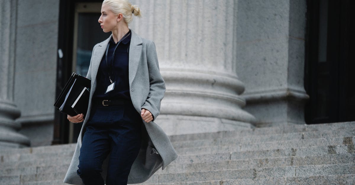 Does "building effectiveness" affect all manageable structures? - Serious female lawyer in elegant outfit holding folders with documents while going downstairs near stone state building and looking away