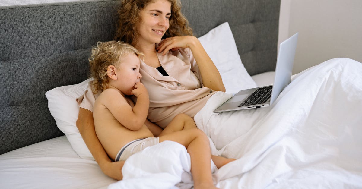 Does sitting around do anything? - A Mother and a Toddler Watching on a Laptop while Sitting on the Bed