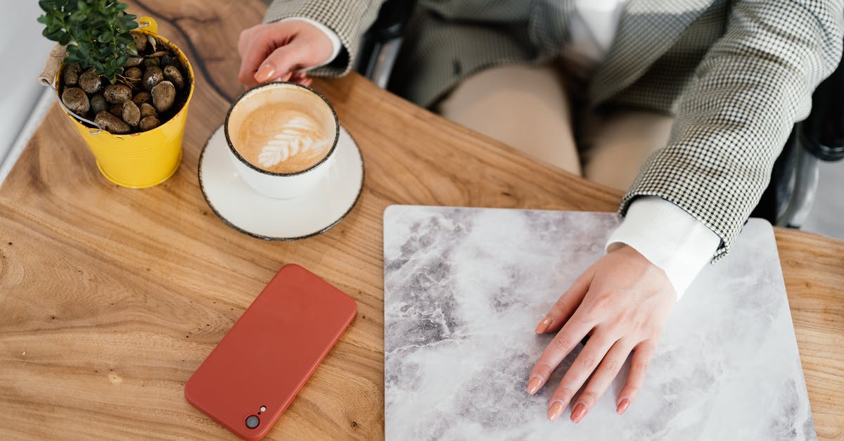 Does stun from artillery disable crew perks? - From above of unrecognizable female freelancer in wheelchair sitting at table with hot coffee and closed netbook during remote work in cafe