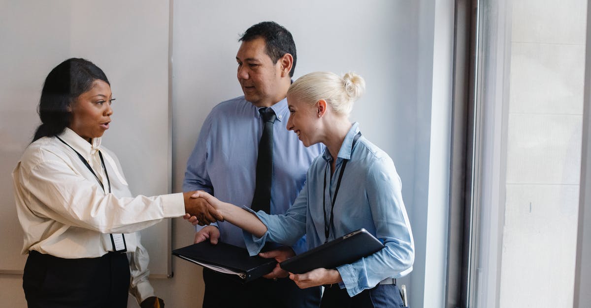 Does the Anti-Bio Beam deal friendly fire? - Happy young multiethnic female managers in classy outfits smiling and shaking hands during meeting with ethnic colleague in office