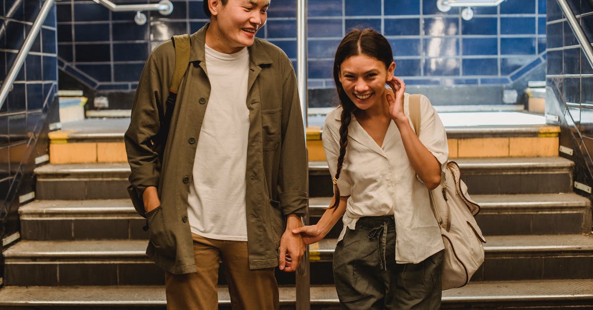 Does the expansion pass also affect the main game? - Happy Asian couple in casual clothes holding hands and walking together in underground hallway