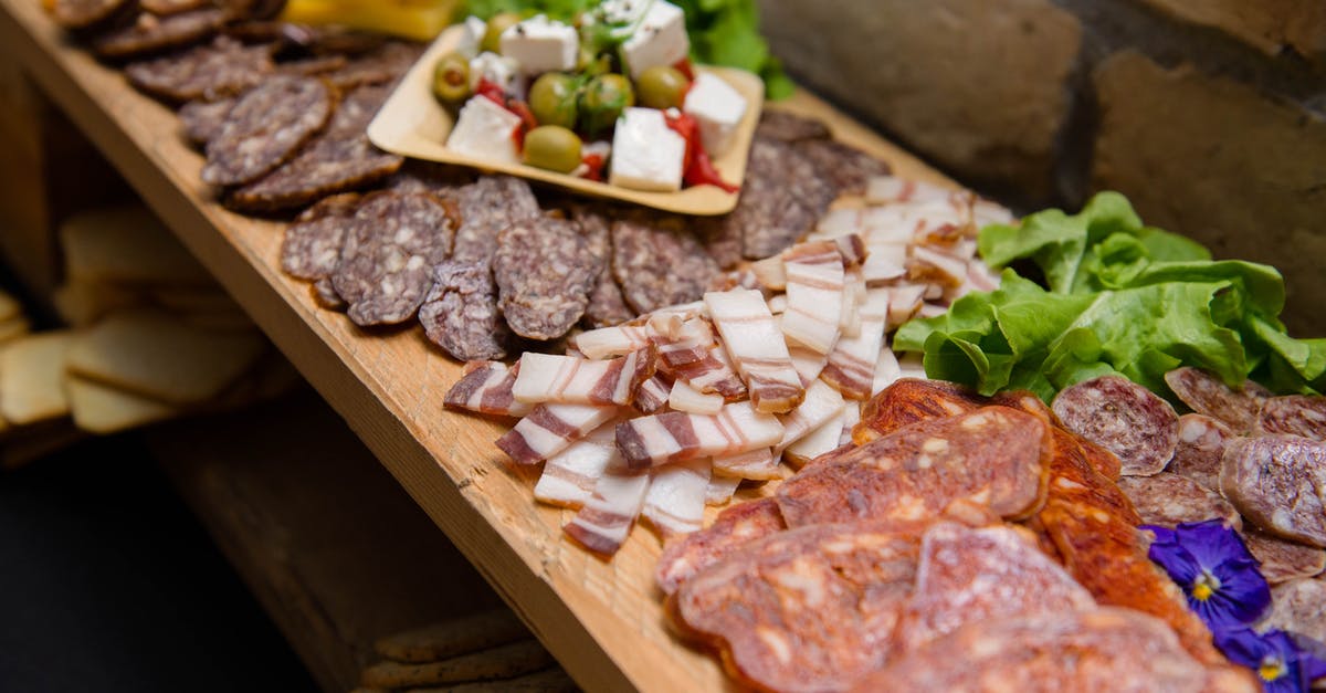 Does what I eat affect how fat I grow? - High angle appetizing sliced cured pork fat and smoked sausages served on sideboard with cheese and olives during buffet catering