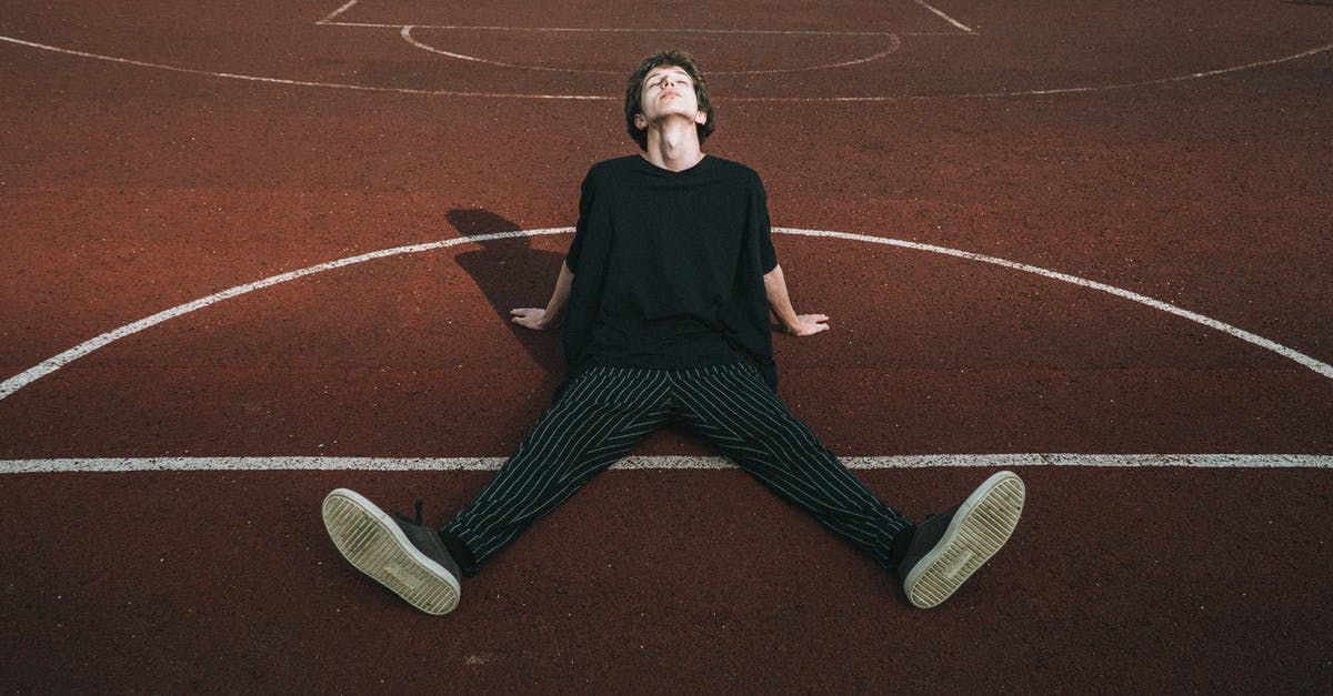 Don't Starve marking on ground question - Male teen in striped trousers leaning with hands on recreation ground on sunny day