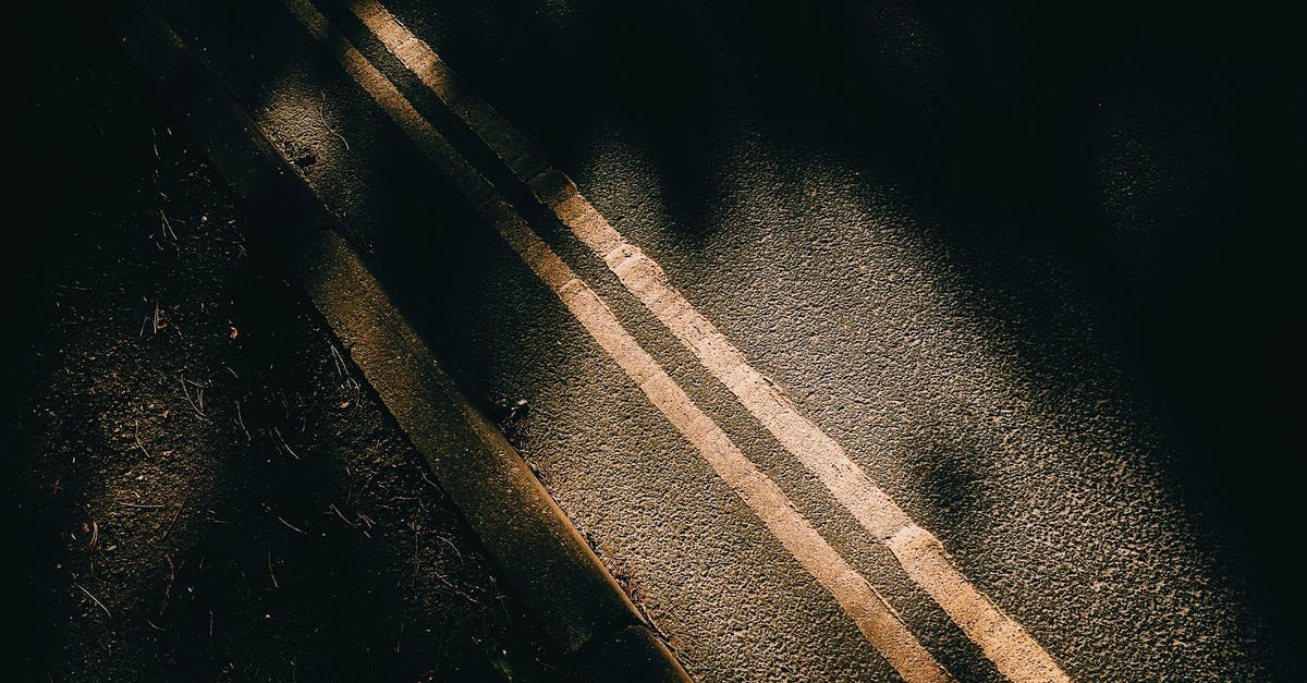 Don't Starve marking on ground question - From above of asphalt roadway with yellow marking lines with dark shades near ground in sunny day in street