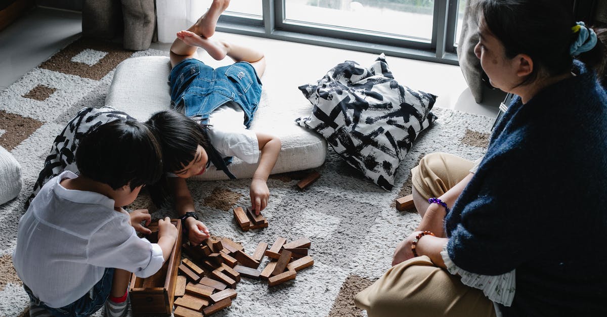 Draught of Living Death/Astronomy Tower Secret Room - From above of Asian boy and girl playing with wooden blocks near window on floor in living room with grandmother