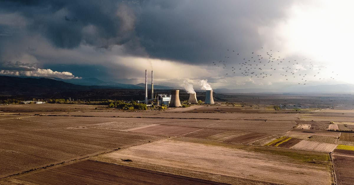 Efficient use of Construction Robots - Aerial view of empty fields near atomic power station generating energy and polluting atmosphere