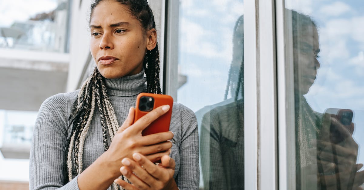 Explaining the solution for this treetop area puzzle - Low angle of concerned ethnic female with smartphone in stressful situation near glass wall