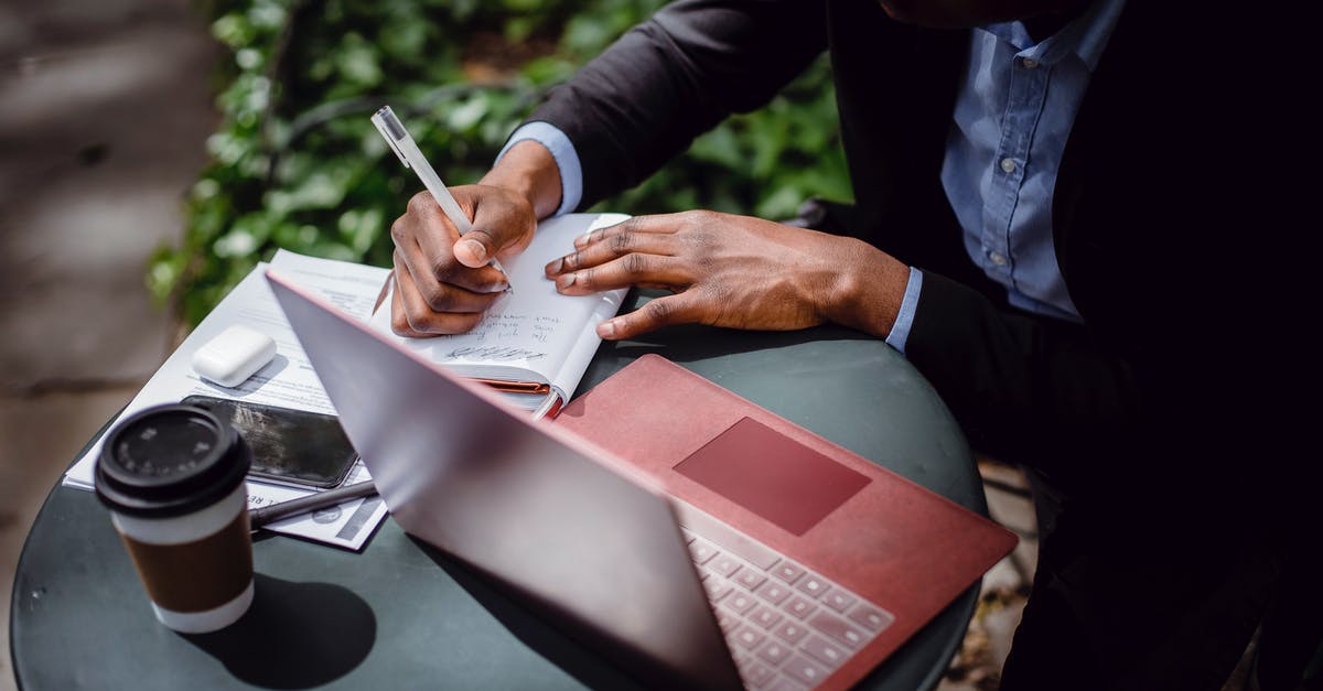 Failed to create D3D9 Device! - From above of crop black male journalist in formal wear writing article while sitting at table with red laptop and cup of takeaway coffee