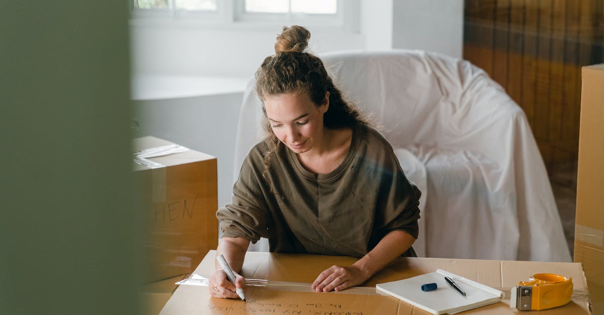 FFXIV window size - Woman signing box with marker while sitting in living room