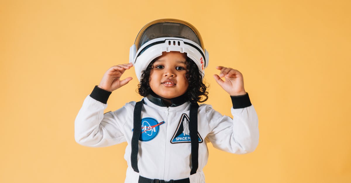 Final Fantasy 7 missing content/trophies - Cheerful little African American girl wearing white astronaut spacesuit and helmet and looking at camera contentedly while standing against brown wall