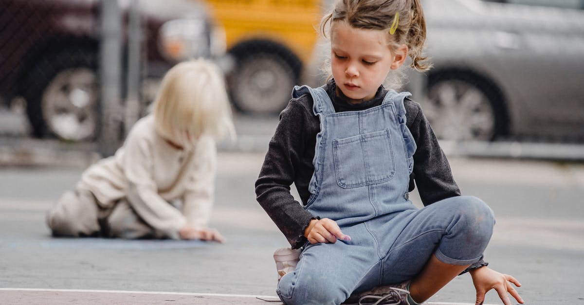 Final Fantasy 7 missing content/trophies - Full body little positive girl wearing casual jumpsuit drawing with chalks on asphalt road on street