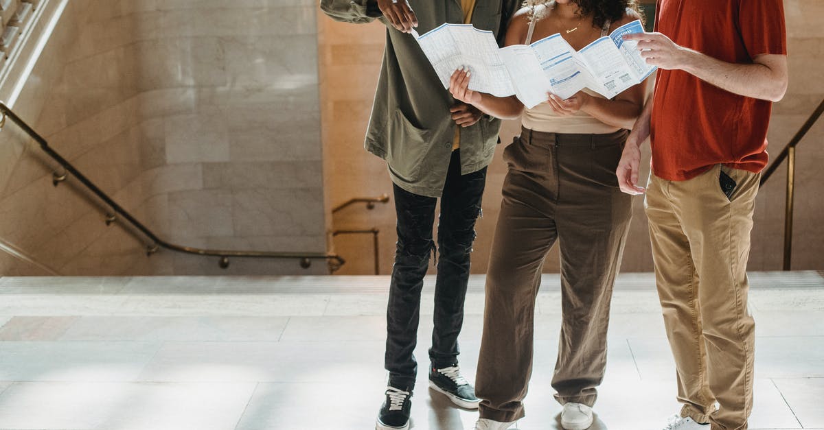 Find a Minecraft SMP server seed based on known locations - Concentrated young Hispanic lady reading map while standing near staircase of old building during vacation with crop multiethnic male friends