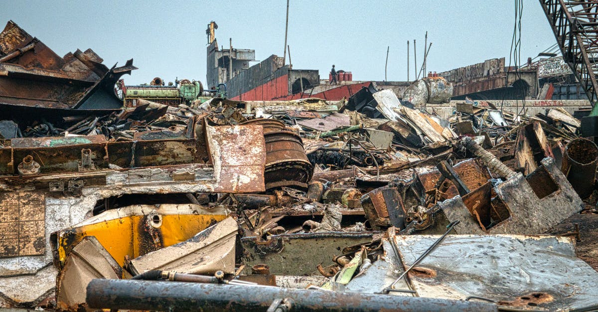 Find out the amount of Heavy Cargo required - Metal rusty worn out constructions with cargo crane on dump in neglected area