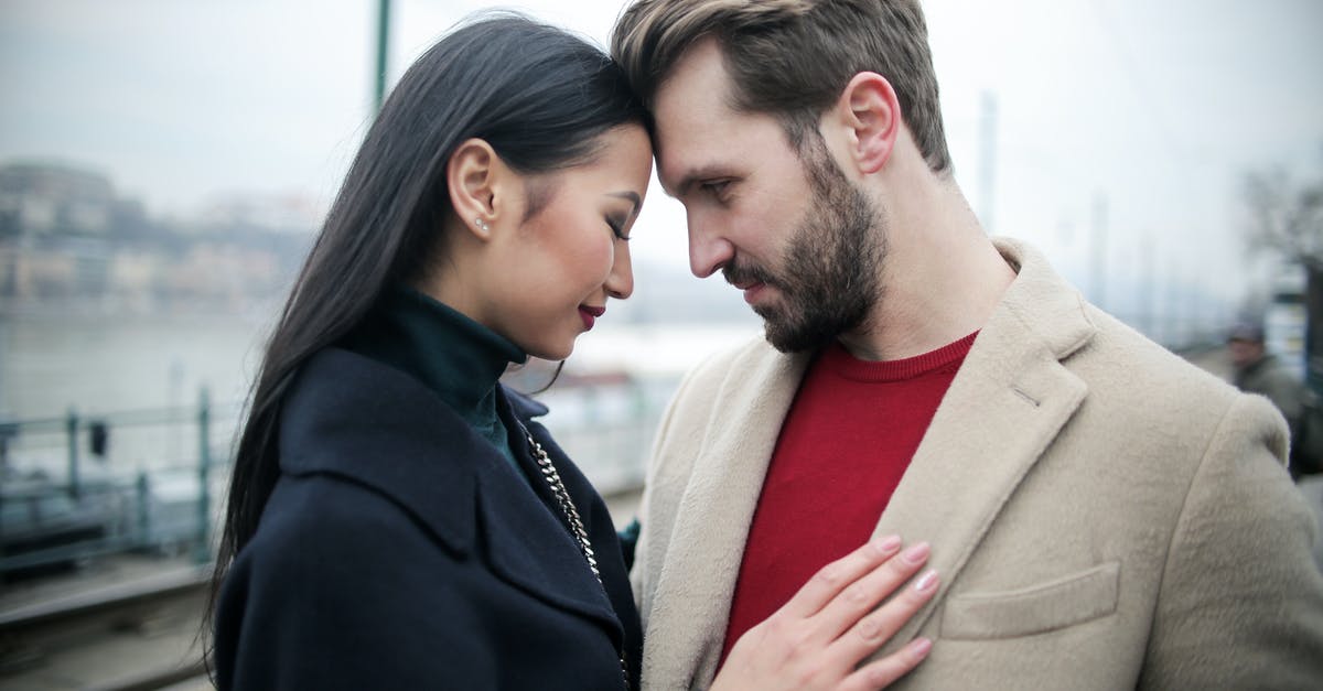 Finding discrepancy on work end date and stay duration - Happy multiracial couple hugging on waterfront while having romantic date in city