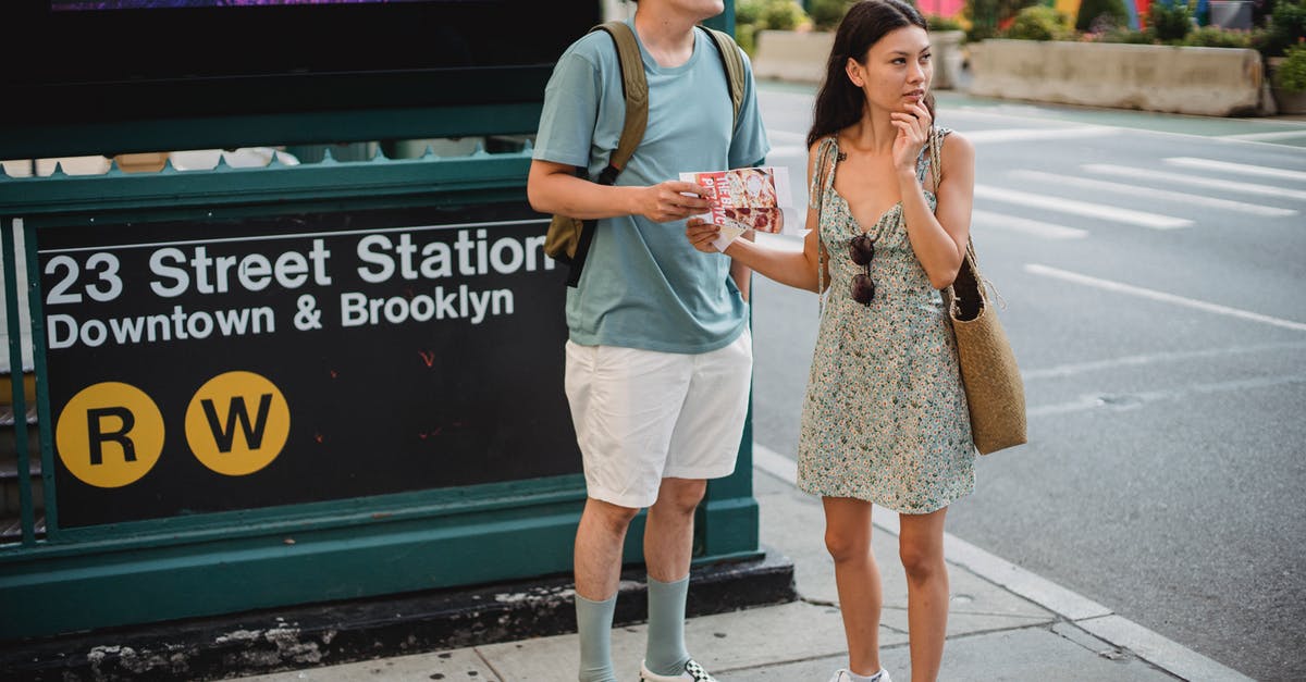 Finding the End city - Full body of diverse couple standing with map while trying to find direction in city center during trip