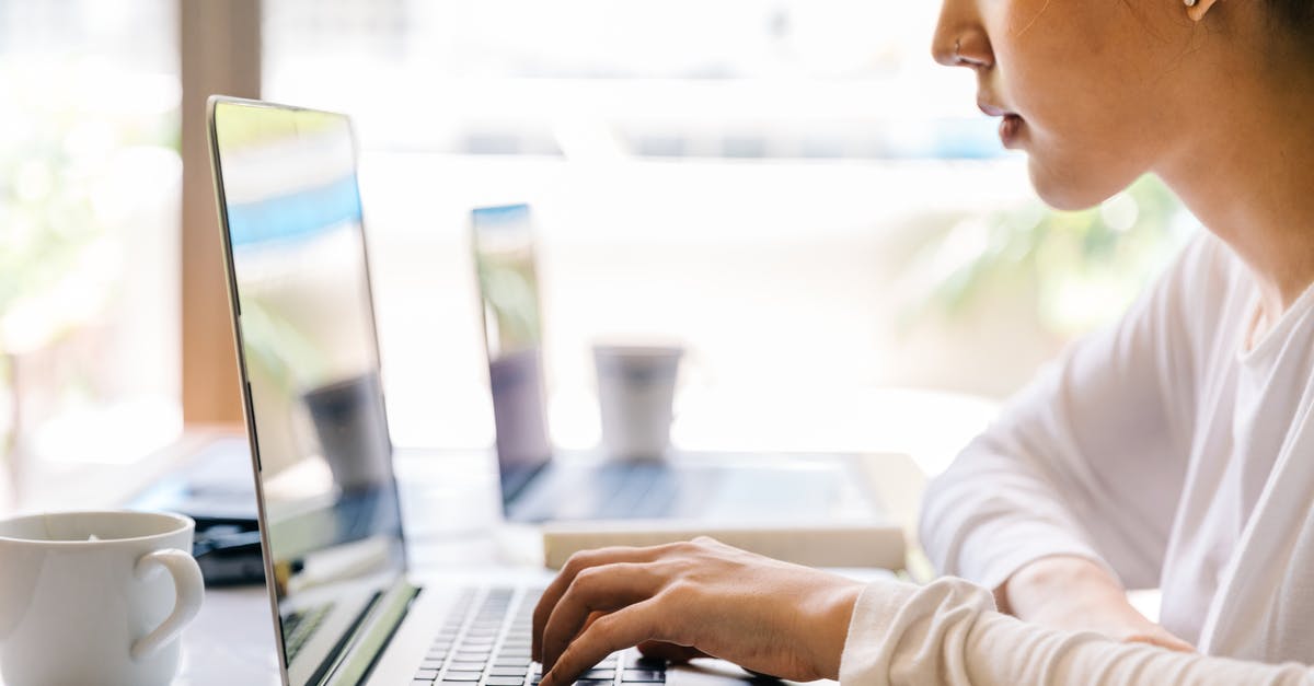 Focus keyboard input in chat windows when in champion selection - Side view of crop serious Asian lady in casual wear sitting at table with cup of beverage and browsing netbook against big glass window on sunny day