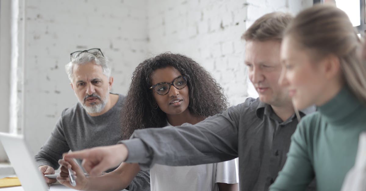 Freeze issue when trying to use Nvidia - Male employee pointing at portable computer screen while expressing opinion about work project to diverse colleagues sitting at desk in office