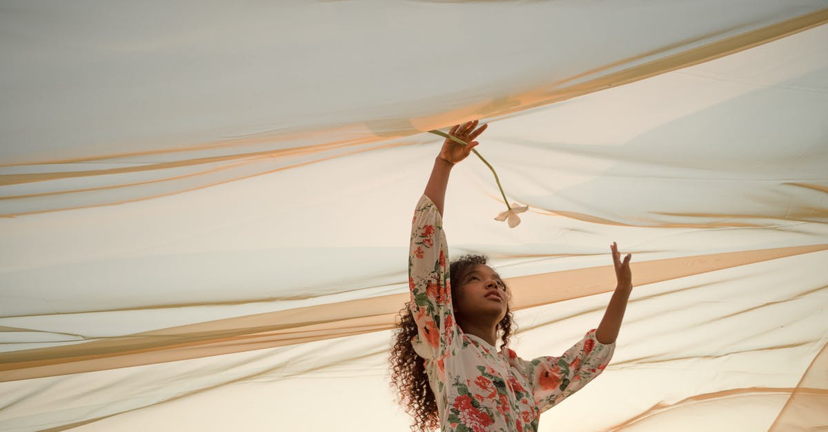 Gamilat stands under the platform? - Woman Standing Under See-Through Fabric Holding Flowers