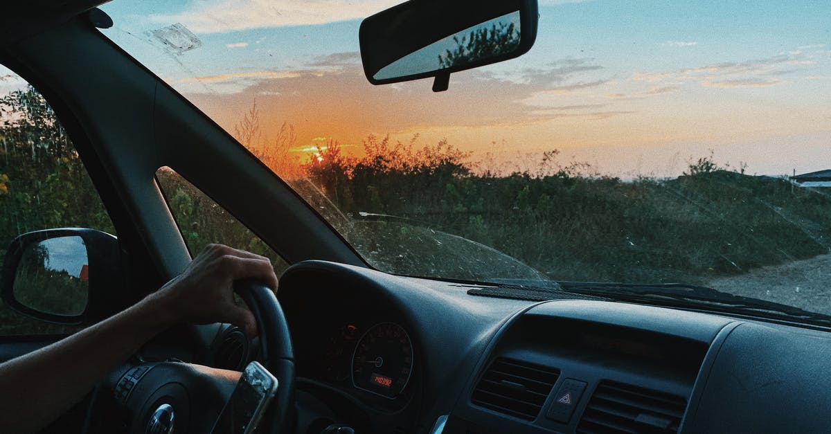 Have Elite Dangerous use Stereo instead of Hands-Free? - Crop unrecognizable person browsing mobile phone and driving car along rural gravel road in sunset time