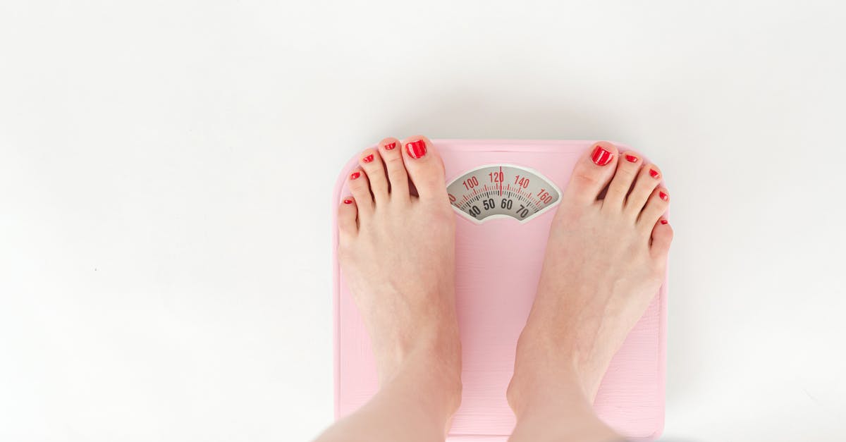 How are PP scores from 'Top Ranks' weighted? - Top view of crop anonymous barefoot female measuring weight on scales on white background