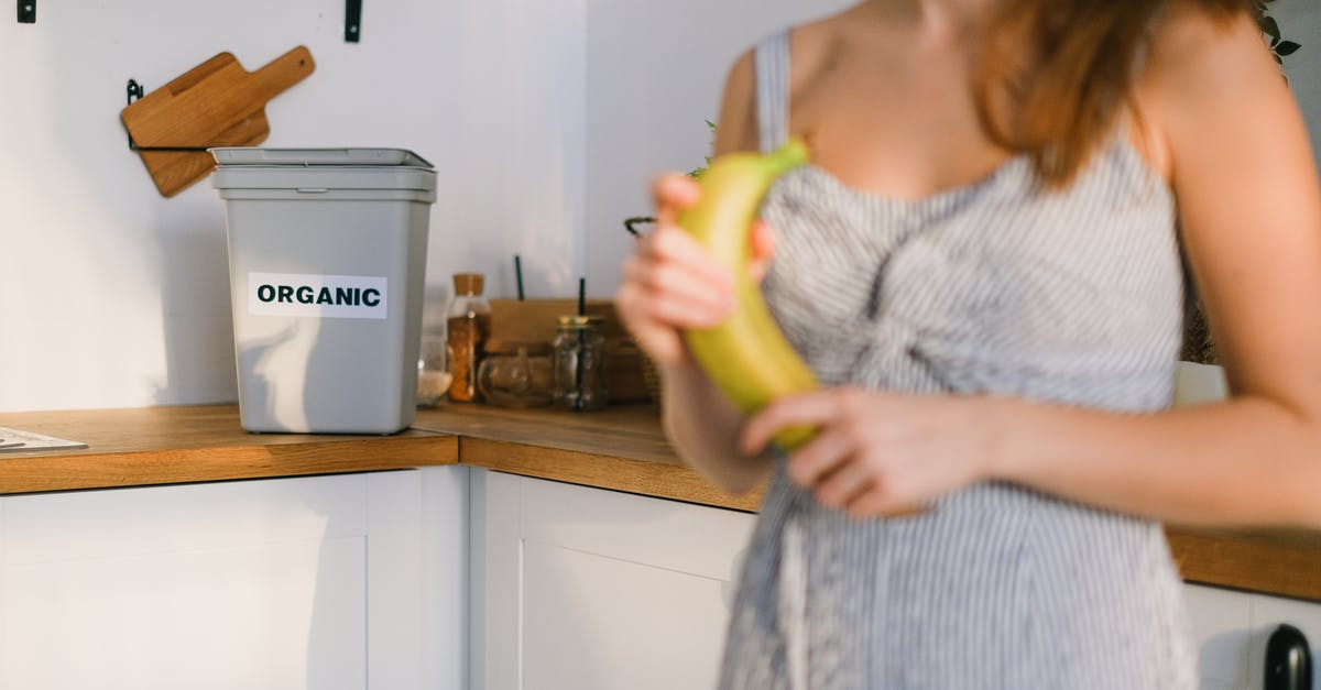 How can I automate my crop harvest? - Crop woman with organic banana in hands standing in kitchen