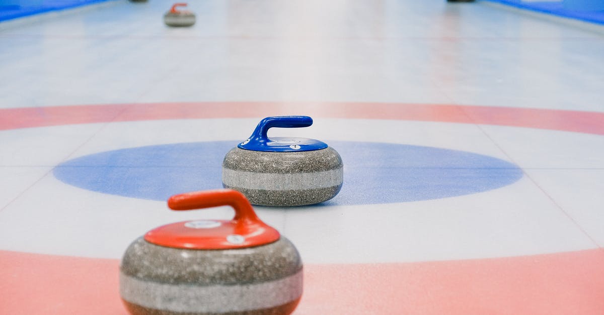 How can I boost mouse cursor speed in game menu? - Red and blue handled curling stones placed on circles of house of ice arena while competition