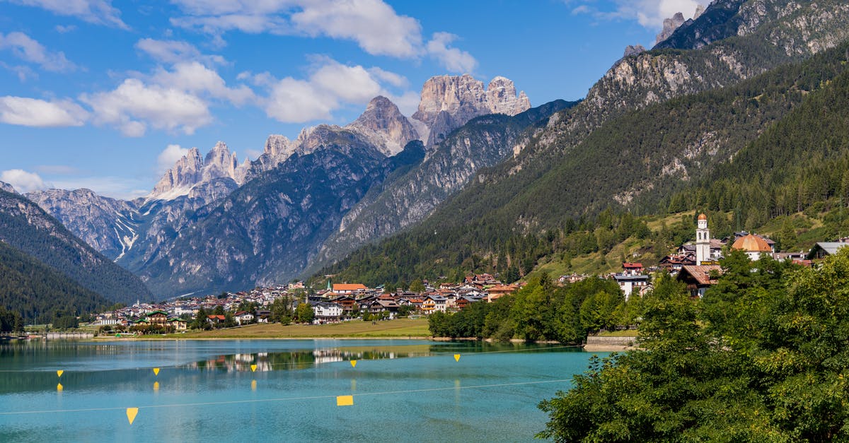 How can I build on top of lakes? - Scenery of rippling blue pond surrounded by residential buildings of settlement located among high steep mountains