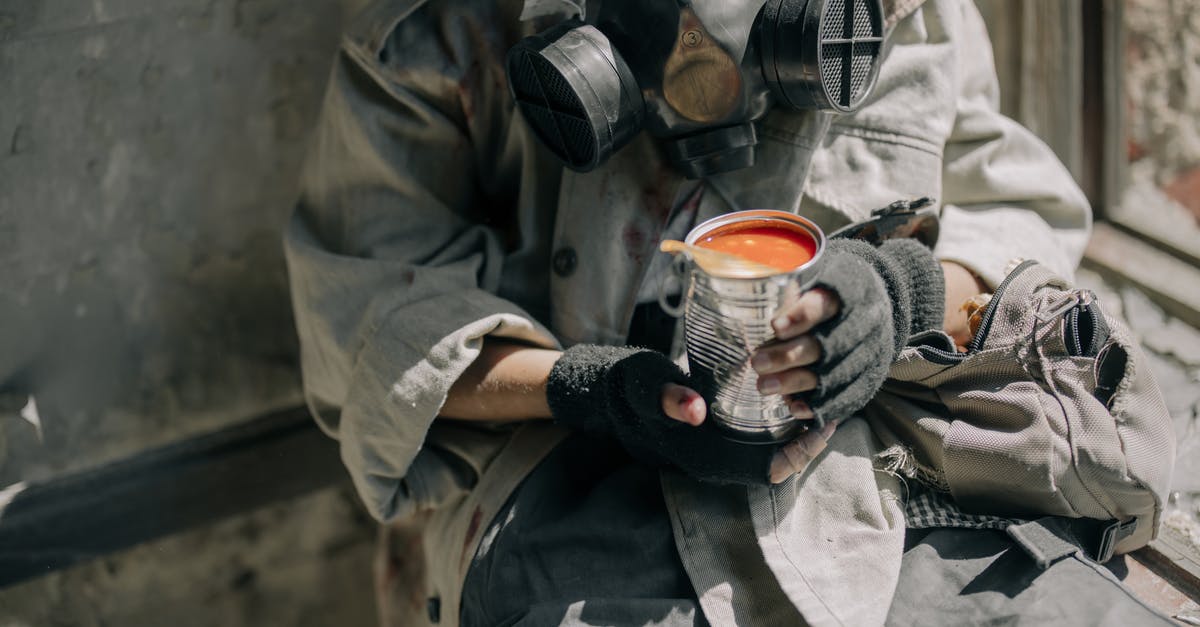 How can I enable the console in Survival mode? - Person in Gray Jacket Holding White and Red Ceramic Mug