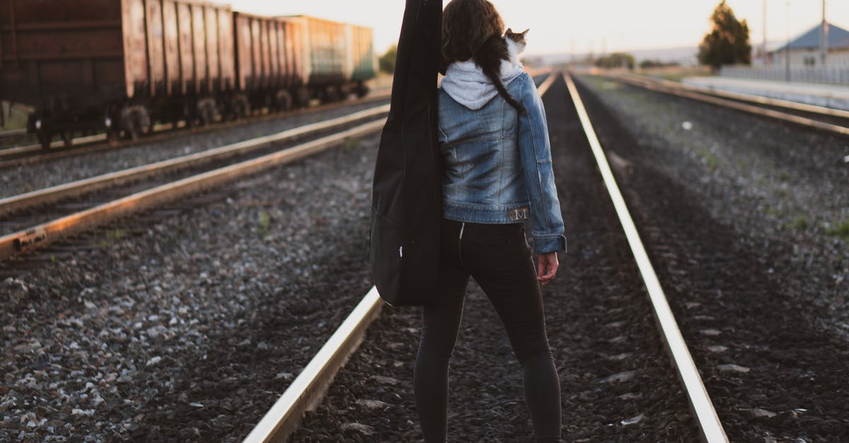 How can I find the way back to the runway? [duplicate] - Woman Standing on Train Rail