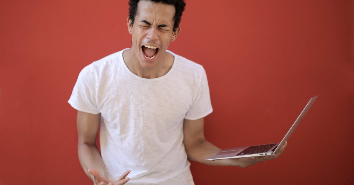 How can I make people stop freaking out when I drive? - Guy with opened mouth and closed eyes screaming madly while standing with laptop against red background