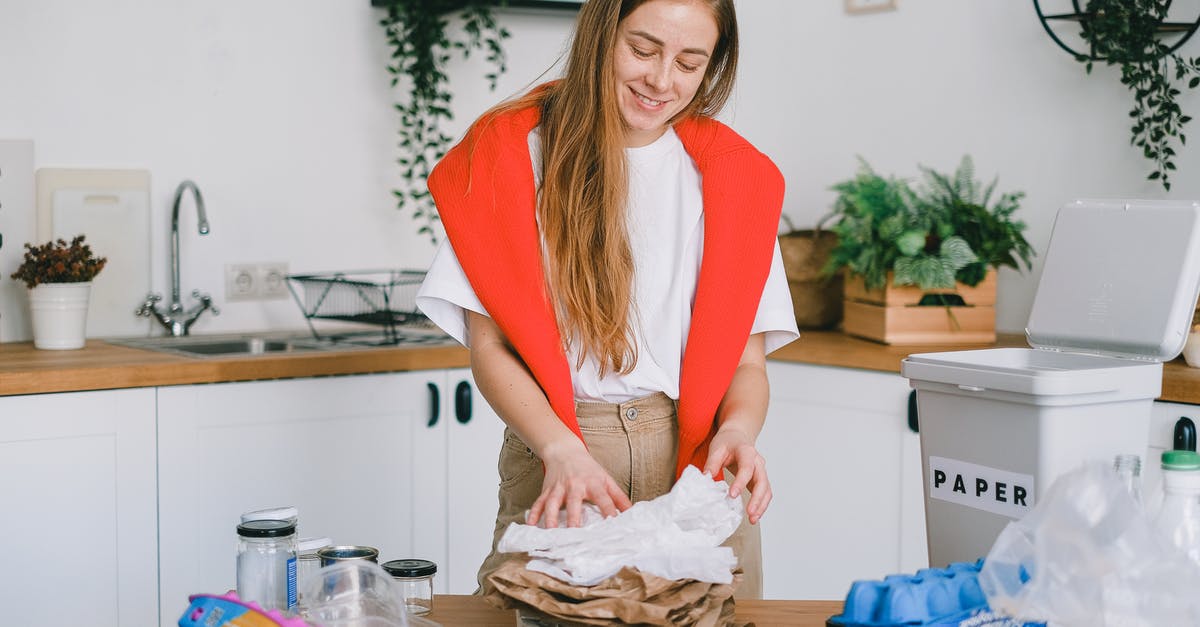 How can I sort items in my PokéBag? - Smiling woman stacking paper litter for reuse