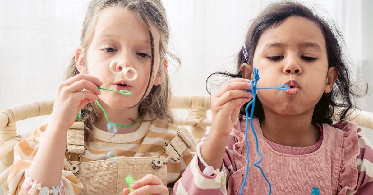 How Can I Stop TNT From Blowing Up? - Two Girls Sitting on Rattan Chair Blowing Soap Bubbles