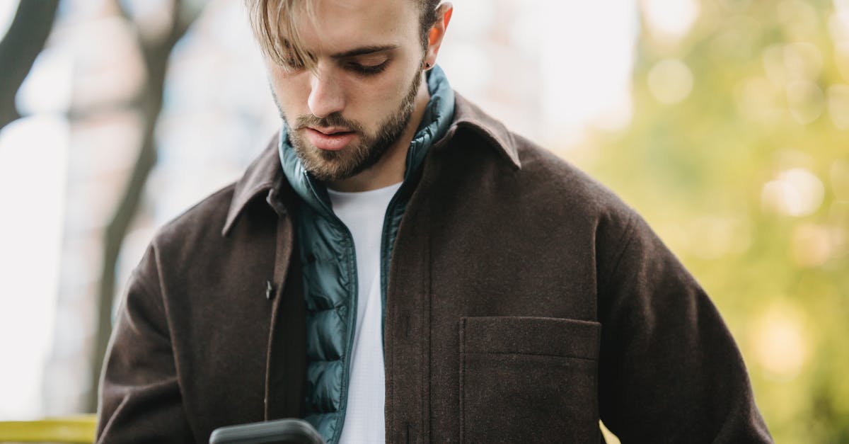 How did I get extra pastures? - Young hipster looking at smartphone screen in park