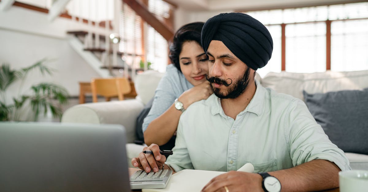 How do activities with my spouse work? - Young smiling woman hugging concentrated husband from behind while counting bills on calculator in modern apartment