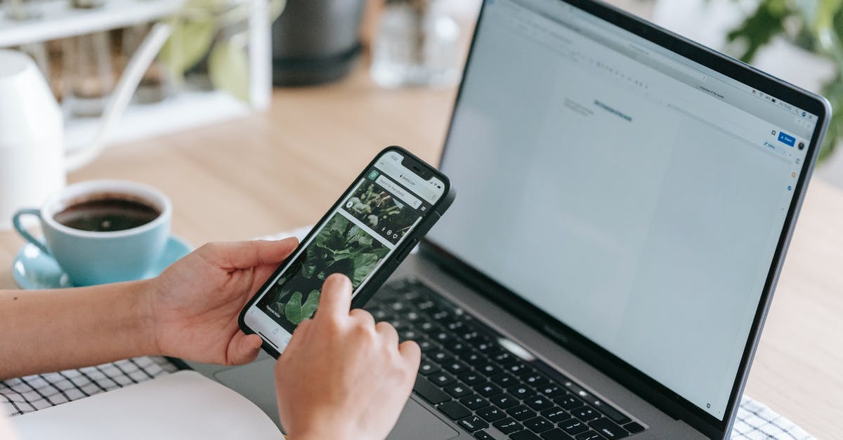 How do Desktop Only items get into my Mobile world? - Faceless person browsing smartphone near laptop