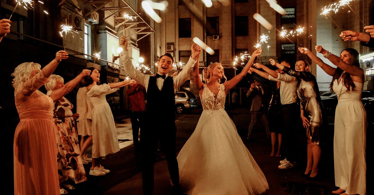 How do extra party members affect fullness when ordering food? - Cheerful young bride and groom with guests dancing on street with sparklers in hands during wedding party