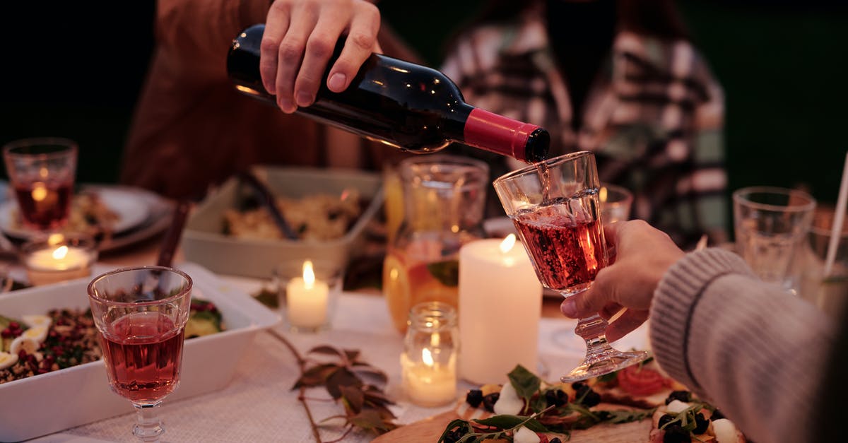 How do extra party members affect fullness when ordering food? - Crop man pouring wine to people on family dinner