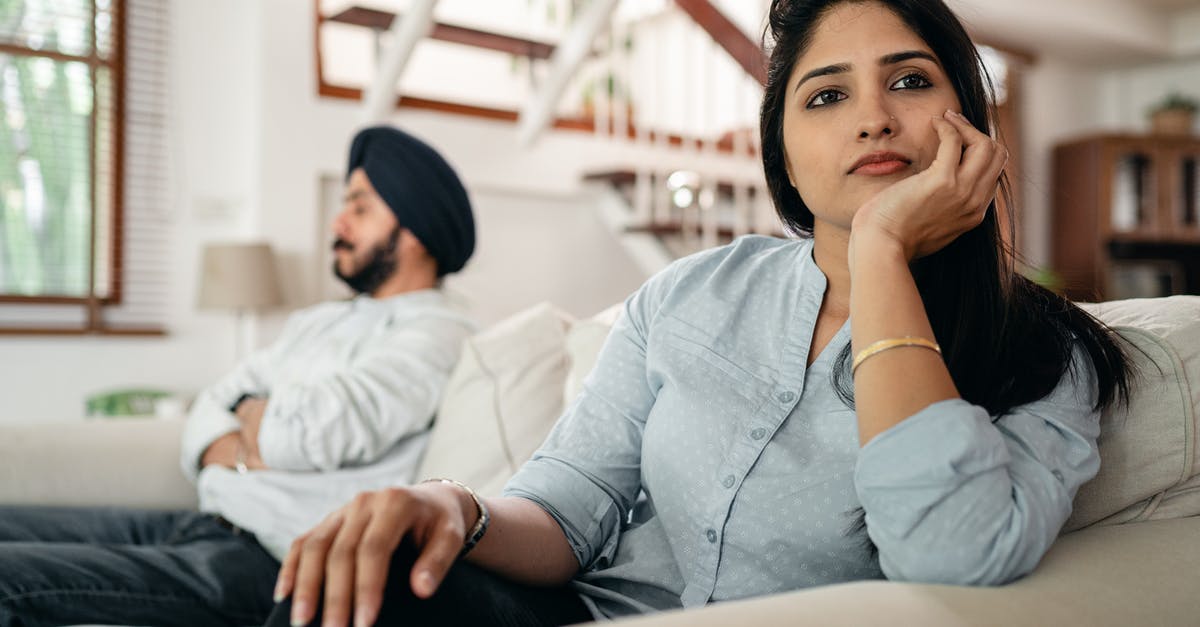 How do I avoid being seen in Gerudo fortress? - Sad young Indian woman avoiding talking to husband while sitting on sofa