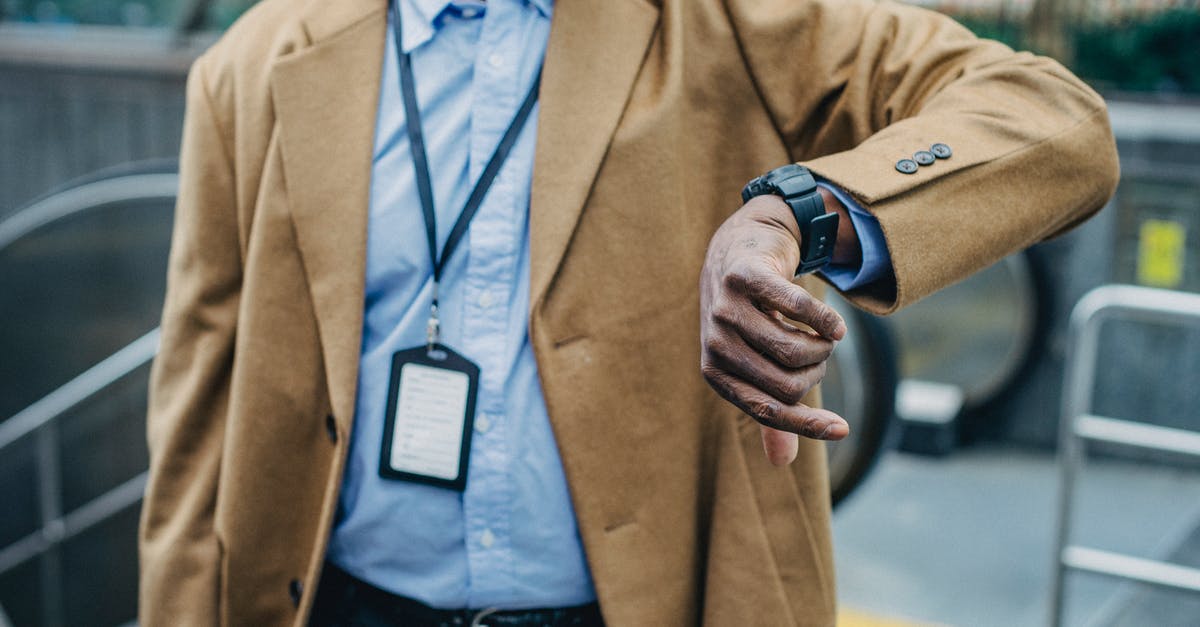 How do I check the time remaining in a song without enabling Advanced HUD? - Crop anonymous African American businessman in elegant formal suit looking at wristwatch while standing near metro entrance