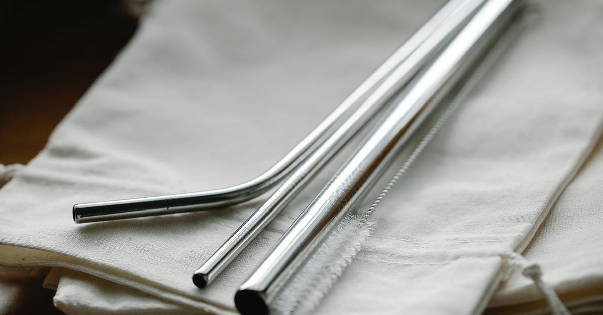 How do I clean items? - Collection of stainless steel straight and bent straws placed on reusable bags on table