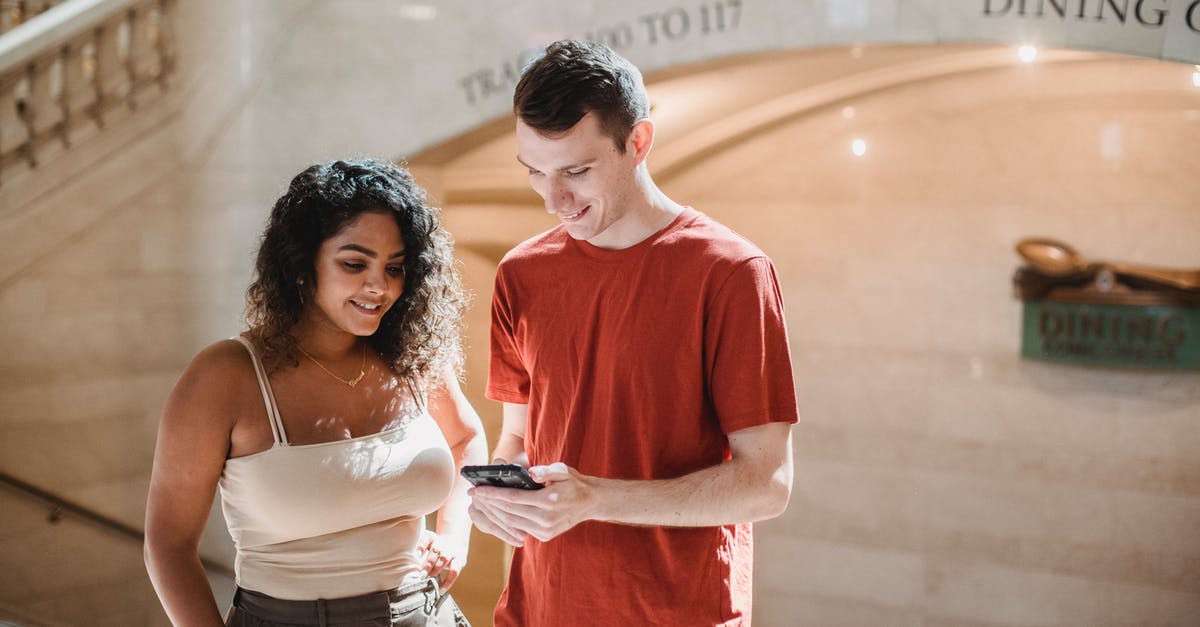 How do I connect the terminal to the turret - Positive young multiethnic couple browsing smartphone during trip in New York