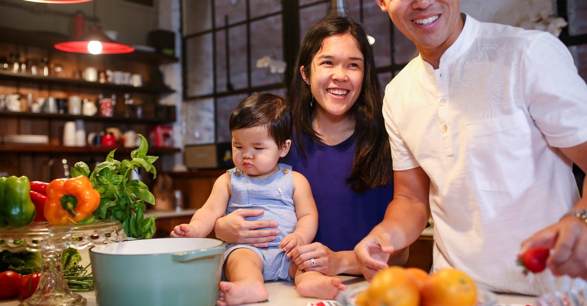 How do I counter a baby dragon? - Man and Woman Standing beside a Child Sitting on White Counter