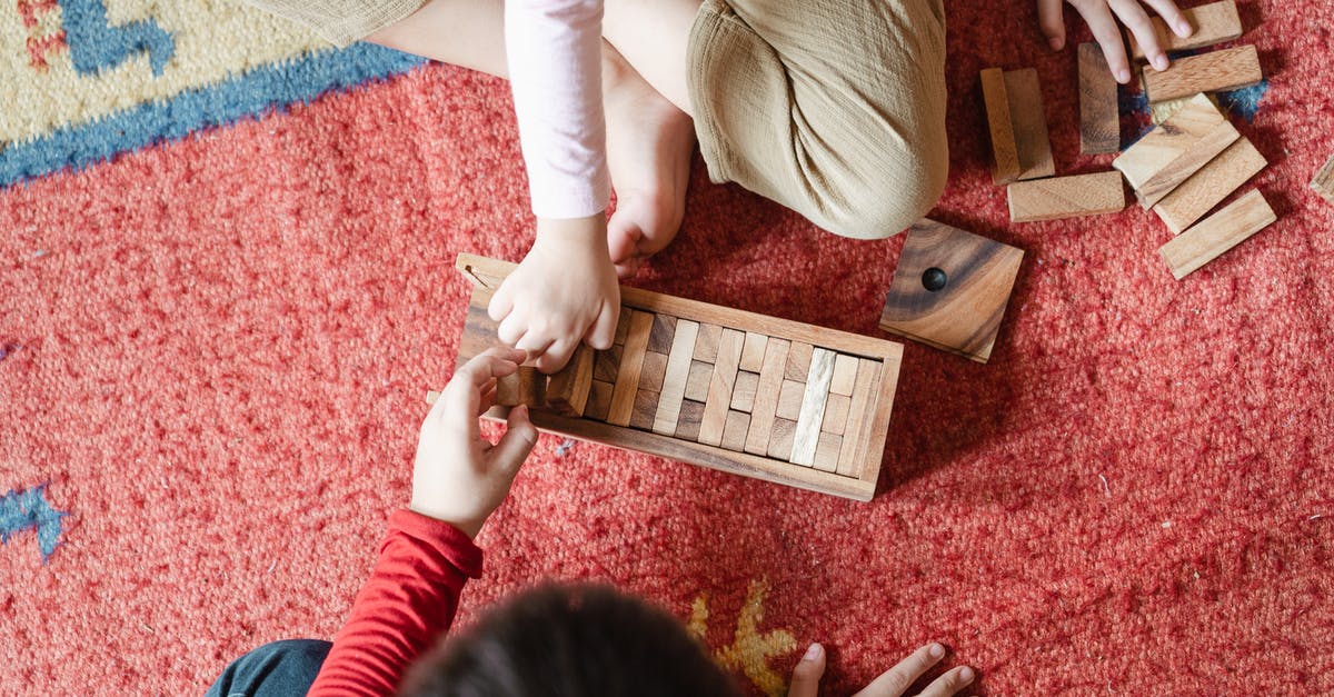 How do I create these seemingly missing building block shapes in 7 Days to Die? - Top view of anonymous barefoot boy and girl in casual clothes sitting on floor carpet and playing with wooden blocks of jenga tower game