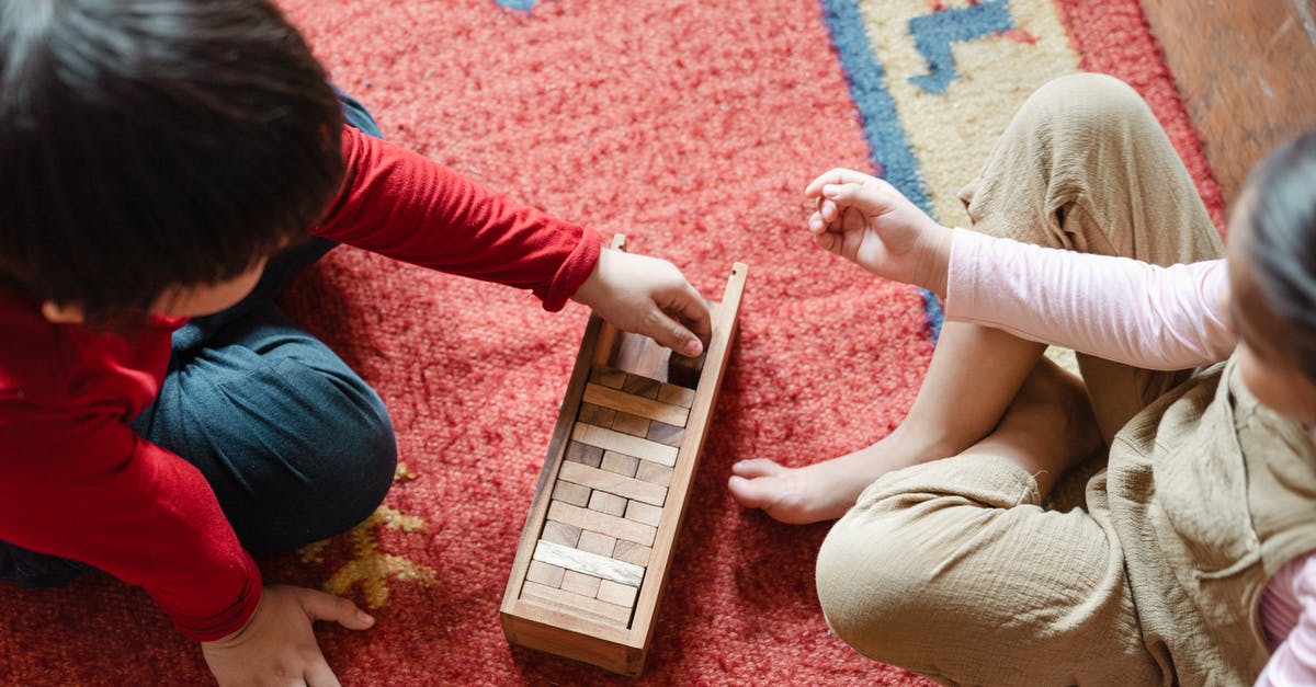 How do I create these seemingly missing building block shapes in 7 Days to Die? - From above of anonymous barefoot boy and girl in casual clothes sitting on floor carpet and playing with wooden blocks of jenga tower game