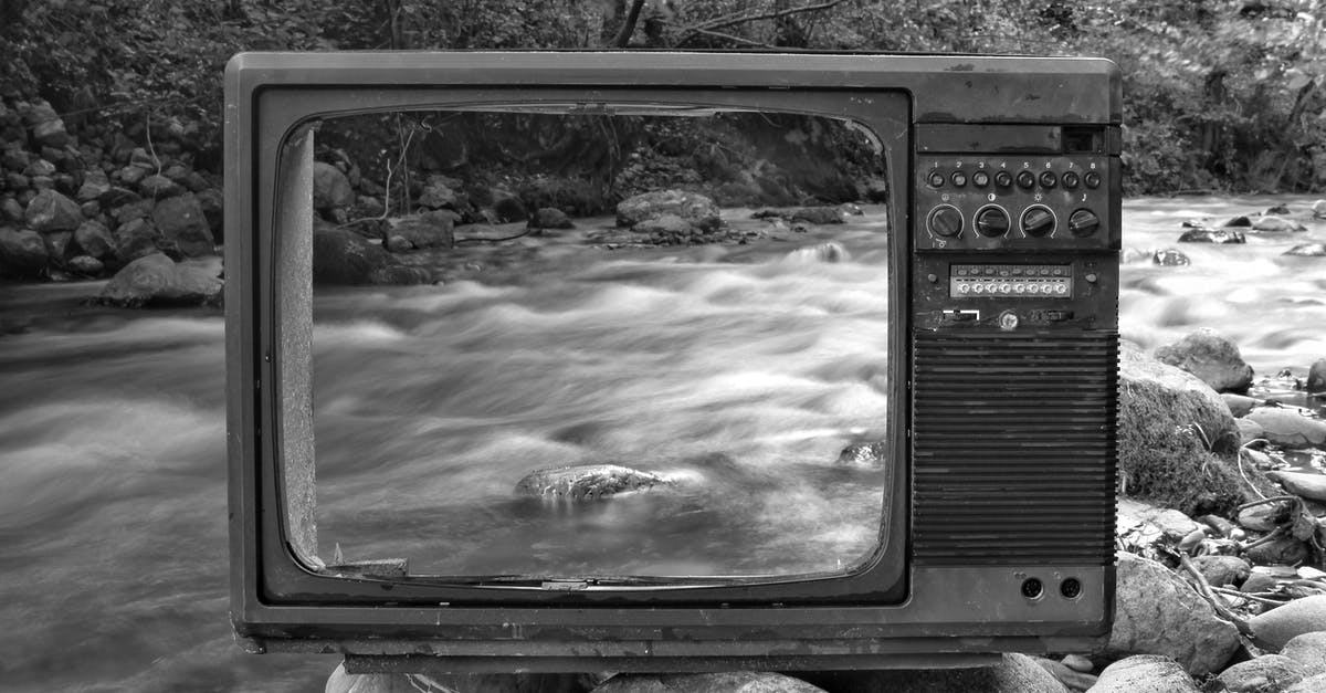 How do I destroy the napalm tank? - Black and white vintage old broken TV placed on stones near wild river flowing through forest