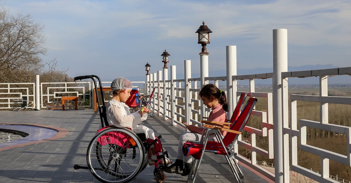 How do I disable chat? - Side view of girl in wheelchair speaking with friend in park under blue sky with clouds